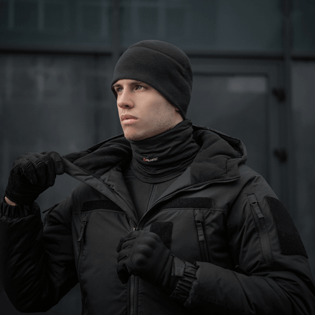 Mand bærer M-Tac Tube Scarf Polartec Power Grid halsrør i sort, der beskytter mod kulde og vind, til udendørs brug.