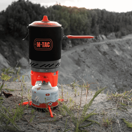 M-Tac Gasbrænder med Kedel i brug på klippe, ideel til camping og vandreture, kompakt og energieffektiv madlavningssystem.