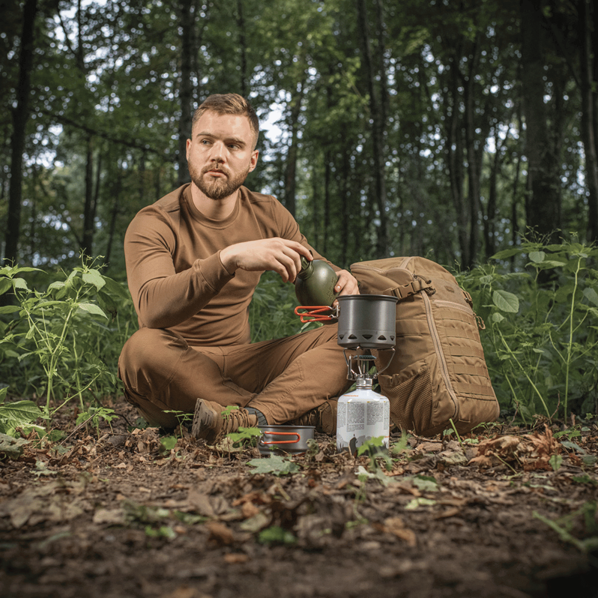 Mand bruger M-Tac Individuelt Kogesæt til Brænder i skoven. Let og holdbart kogesæt af anodiseret aluminium til camping og friluftsliv.