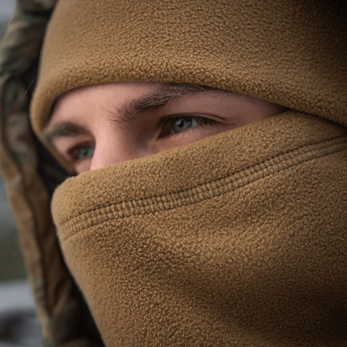 Person iført M-Tac Anatomisk Snood Justerbar Elite Fleece (320 g/m²), velegnet til kolde vejrforhold, beskytter mod vind og støv.