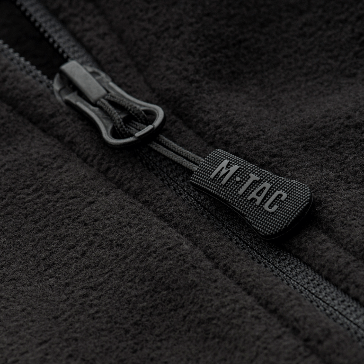 Nærbillede af M-Tac Delta Fleece Jakke lynlås, viser sort fleece stof og lynlåsdetaljer, ideel til udendørs brug i koldt vejr.