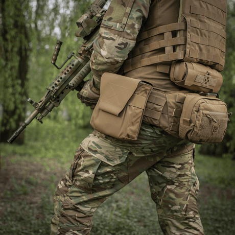 Soldat med M-Tac Pouch til M249 Cartridge Box Closed fastgjort til taktisk vest i feltmiljø, fremhæver holdbarhed og funktionalitet.