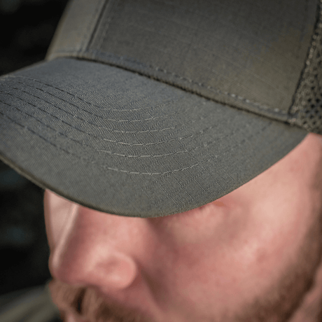 M-Tac Mesh Flex Ripstop Baseball Cap i grøn farve med mesh-paneler for ventilation, set tæt på på en person udendørs.
