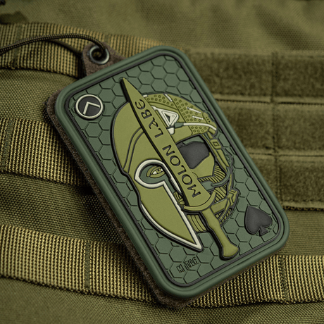 M-Tac Patch Molon Labe 3D PVC med spartansk hjelm og sværd, monteret på taktisk taske med velcro fastgørelse.