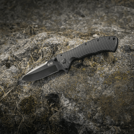 M-Tac Outdoor & Militær foldekniv - Type 7 i sorte belægning på klippebaggrund