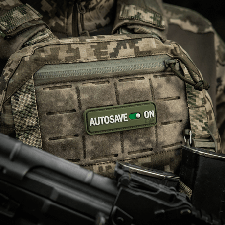 M-Tac Patch Autosave PVC i 3D på taktisk vest, viser detalje i camouflage-look og nem fastgørelse, 8x2.5 cm, full farve.