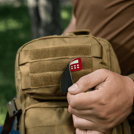M-Tac Patch Flag 25x80 Mini Squares på en taske, holdt af en person. Cordura 500D, velcro montering, laser cut, slidstærk og let patch.