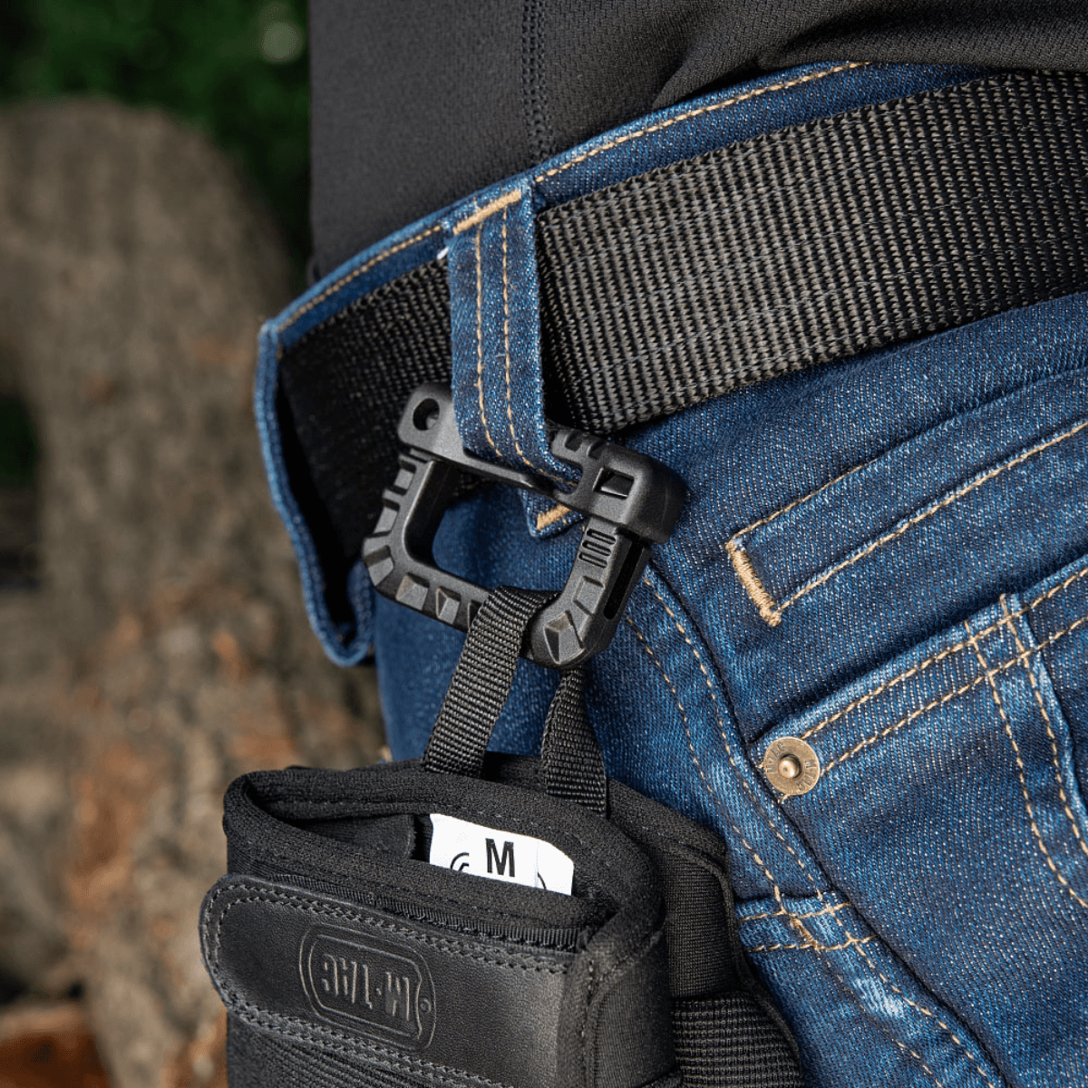 M-Tac Plast Karabin fastgjort på et bælte, nemt at anvende til udstyr, fremstillet af holdbar ABS-plast, let og praktisk til daglig brug.