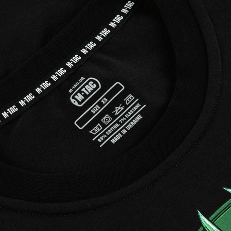 Nærbillede af etiketten på M-Tac T-Shirt Night Vision i sort, lavet af bomuldsblanding, med tydelige vaskeanvisninger og størrelse XS.
