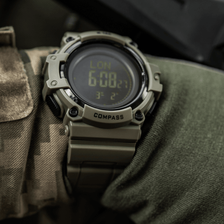 M-Tac Tactical Ur med Kompas 2233 på camouflageærme, robust design med LED-baggrundsbelysning og kompas, ideel til outdoor og taktisk brug.