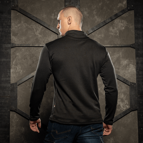 Mand iført M-Tac Thermal Fleece Trøje Delta Level 2, set bagfra, i barsk klimaindstilling. Perfekt til ECWCS lag.