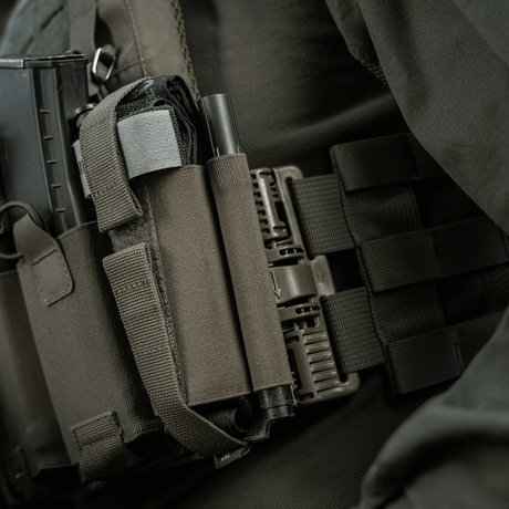 M‑Tac Tourniquet Pouch Elastic Gen.5 monteret på taktisk udstyr med elastisk velcro bånd, praktisk til CAT tourniquet.