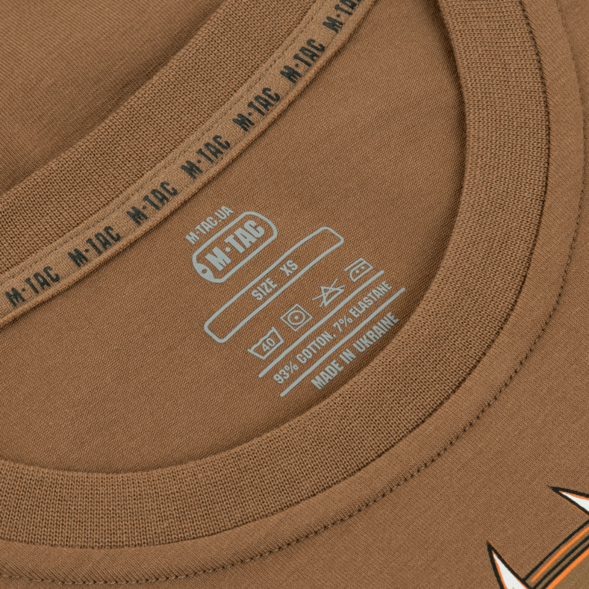 Nærbillede af M-Tac T-Shirt Odin etiket design, der viser størrelse og materialekomposition. Fremstillet af M-Tac.