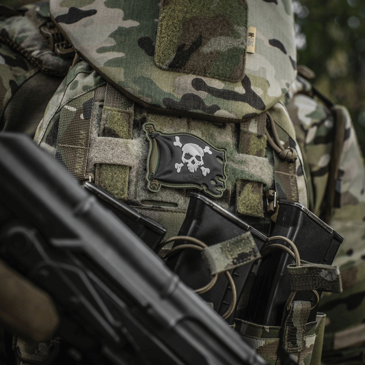 M-Tac Patch Jolly Roger PVC på taktisk udstyr med kamouflage, symboliserer eventyrlyst og beslutsomhed.