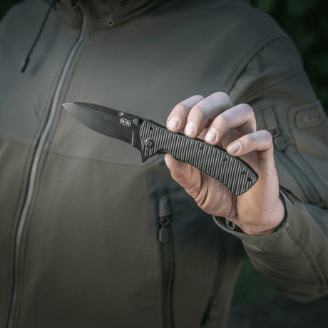 Person holder M-Tac Outdoor & Militær foldekniv - Type 7 med sort klinge og ergonomisk greb, ideel til taktisk brug.
