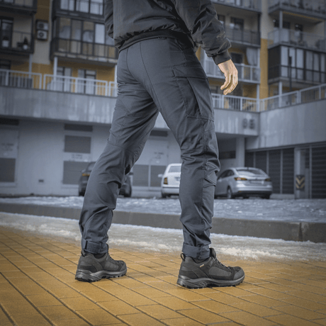 M-Tac Taktiske Bukser Patriot Gen. II Flex i brug til udendørs aktiviteter, fremhæver behagelig pasform og praktiske sidelommer.