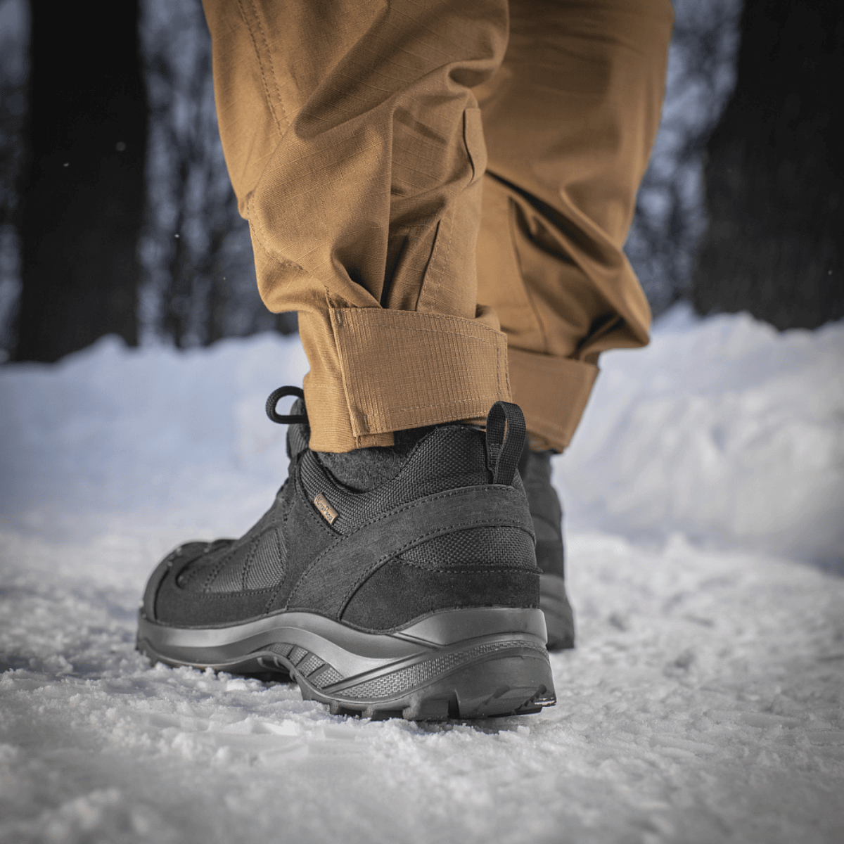 M-Tac Taktiske Bukser Patriot Gen. II Flex til vinterbrug, viser slidstærk stof og bevægelsesfrihed i sneklædt landskab.