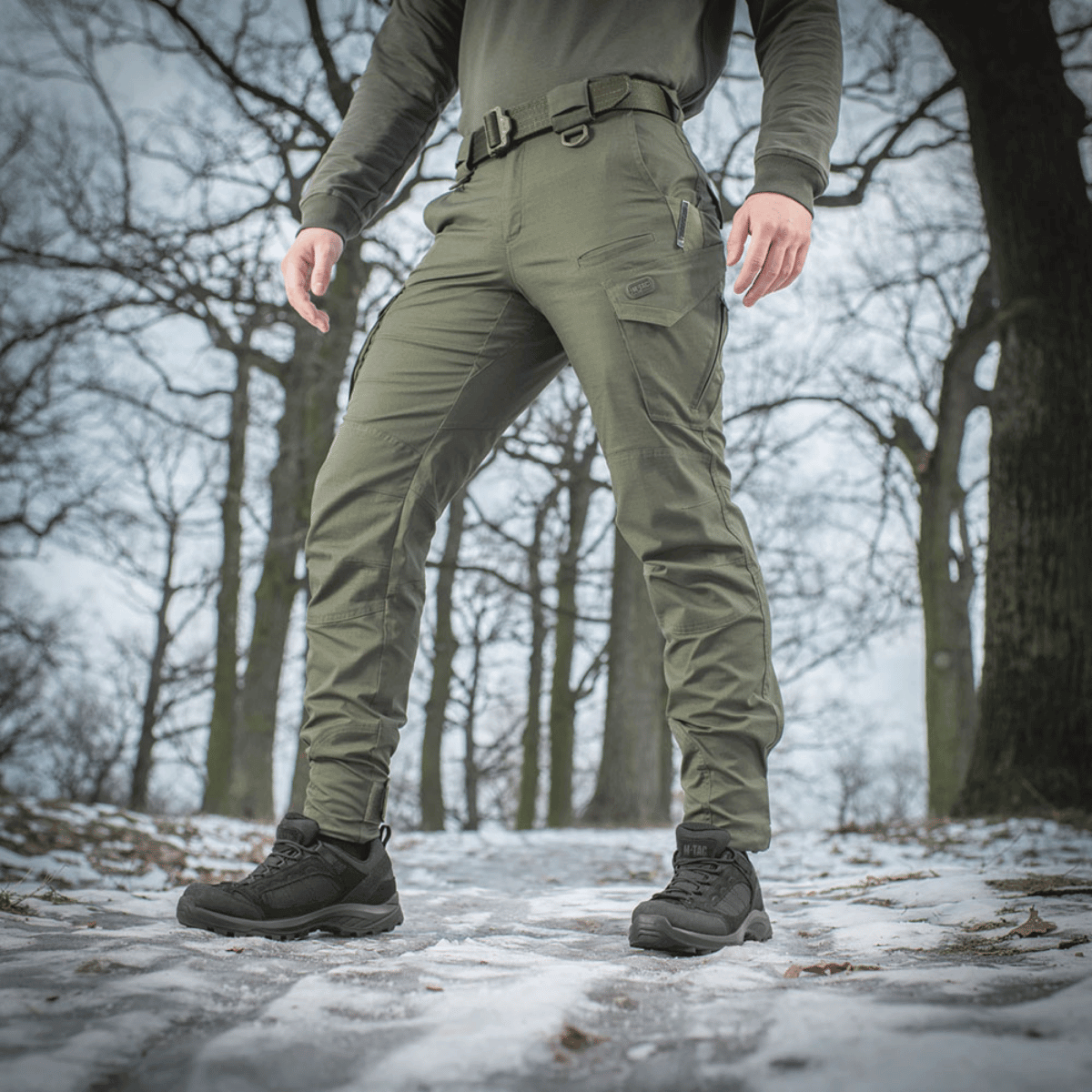 M-Tac Taktiske Bukser Aggressor Gen. II Flex i skovområde, designet til træning og komfort. Funktionelle og holdbare bukser til udendørs aktiviteter.