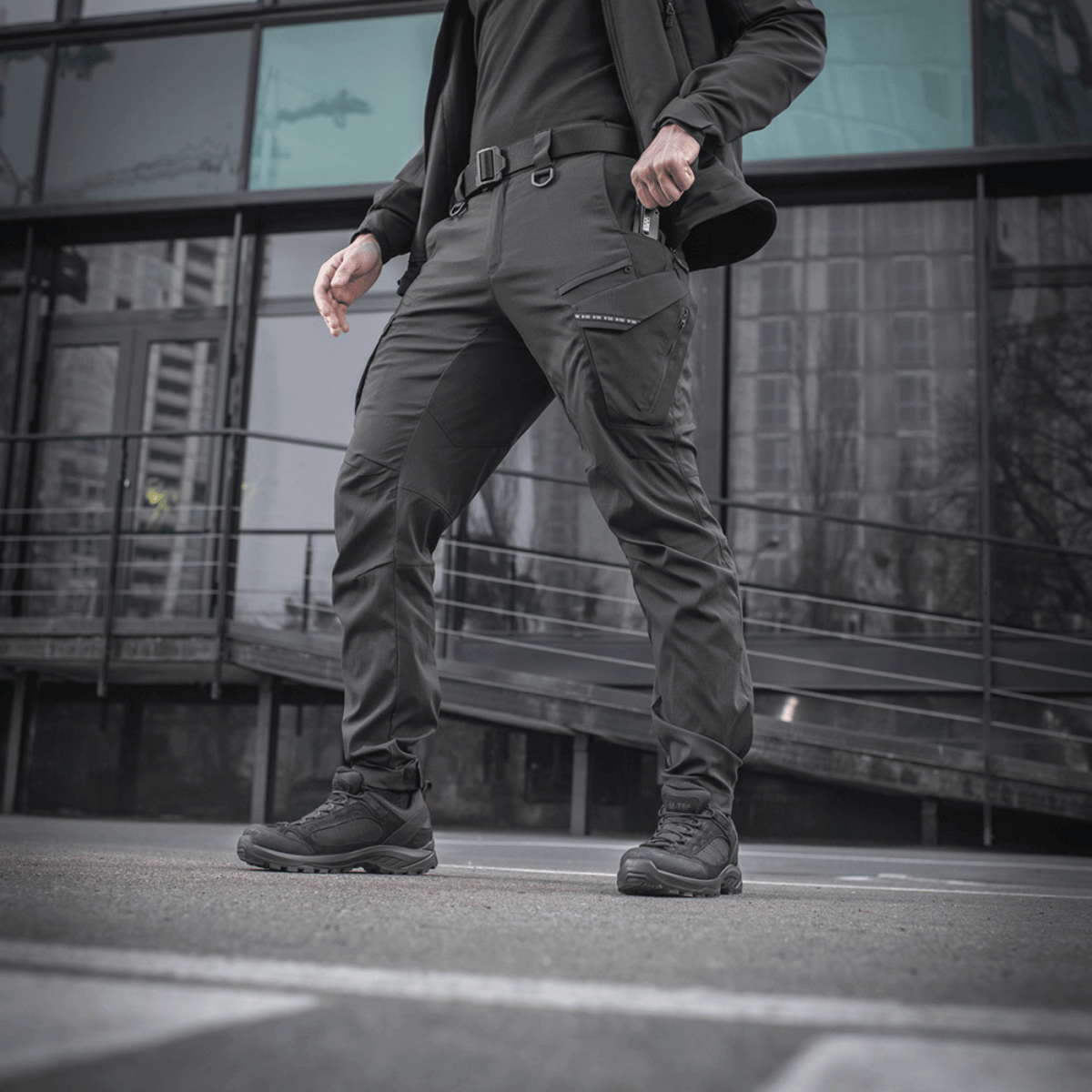 Mand iført M-Tac Bukser Aggressor Summer Flex, designet til komfort og taktisk anvendelse i varmt vejr. Fremstillet af Rip-Stop nylon.