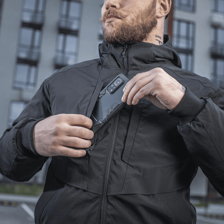 Mand iført M-Tac Rubicon Jakke Gen. II, viser jakke med slidstærkt Cordura-stof og praktisk brystlomme i bymiljø.