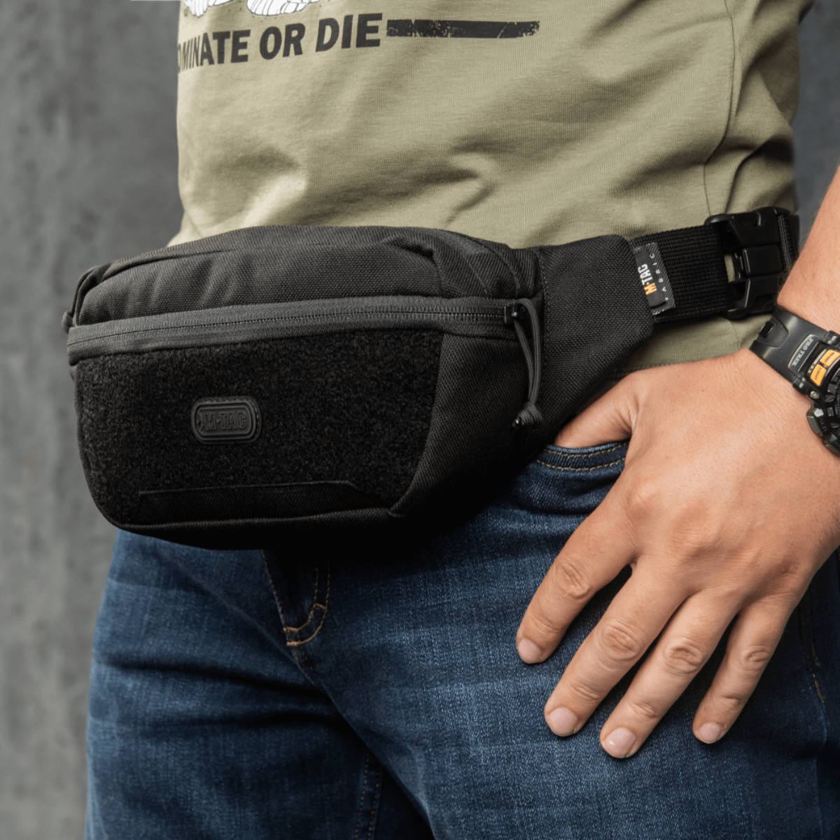 M-Tac Tactical Waist Bag Gen.II Elite bæltetaske fremstillet af slidstærk Cordura 1000D, båret af en person iført jeans.