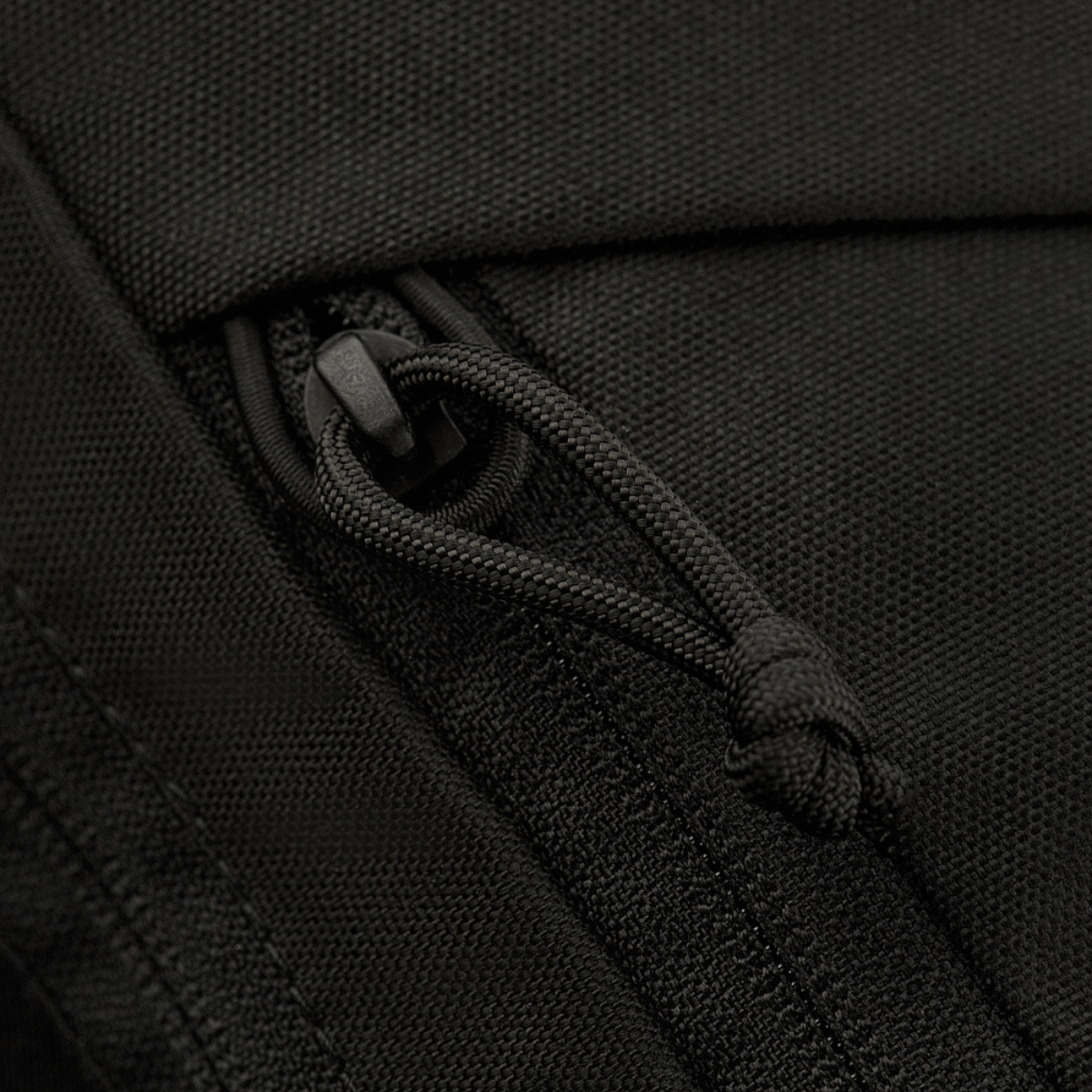 Nærbillede af lynlåsen på M-Tac Magnet XL Bag Elite, en praktisk skuldertaske med innovativ magnetlås og velcro-panel.