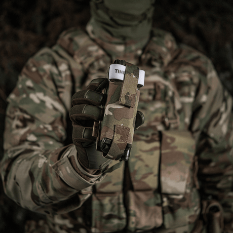 Soldat i camouflageuniform holder M-Tac Elastisk Tourniquet Pouch Molle Gen.III op foran, klar til hurtig adgang.