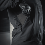 Person i sort jakke holder M‑Tac Pascover med "Passport"-tryk.