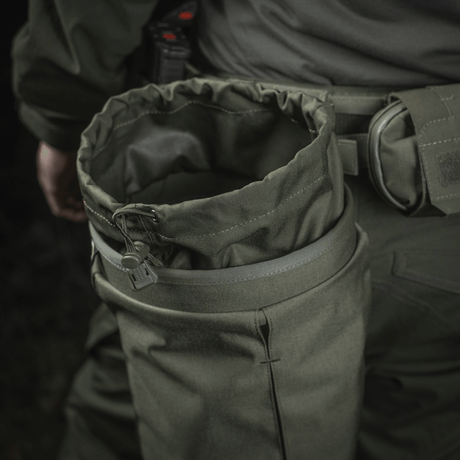 Person wearing M‑Tac Magasinsæk Dump Pouch Lite Elite in green Cordura 500D, attached to belt with MOLLE straps.