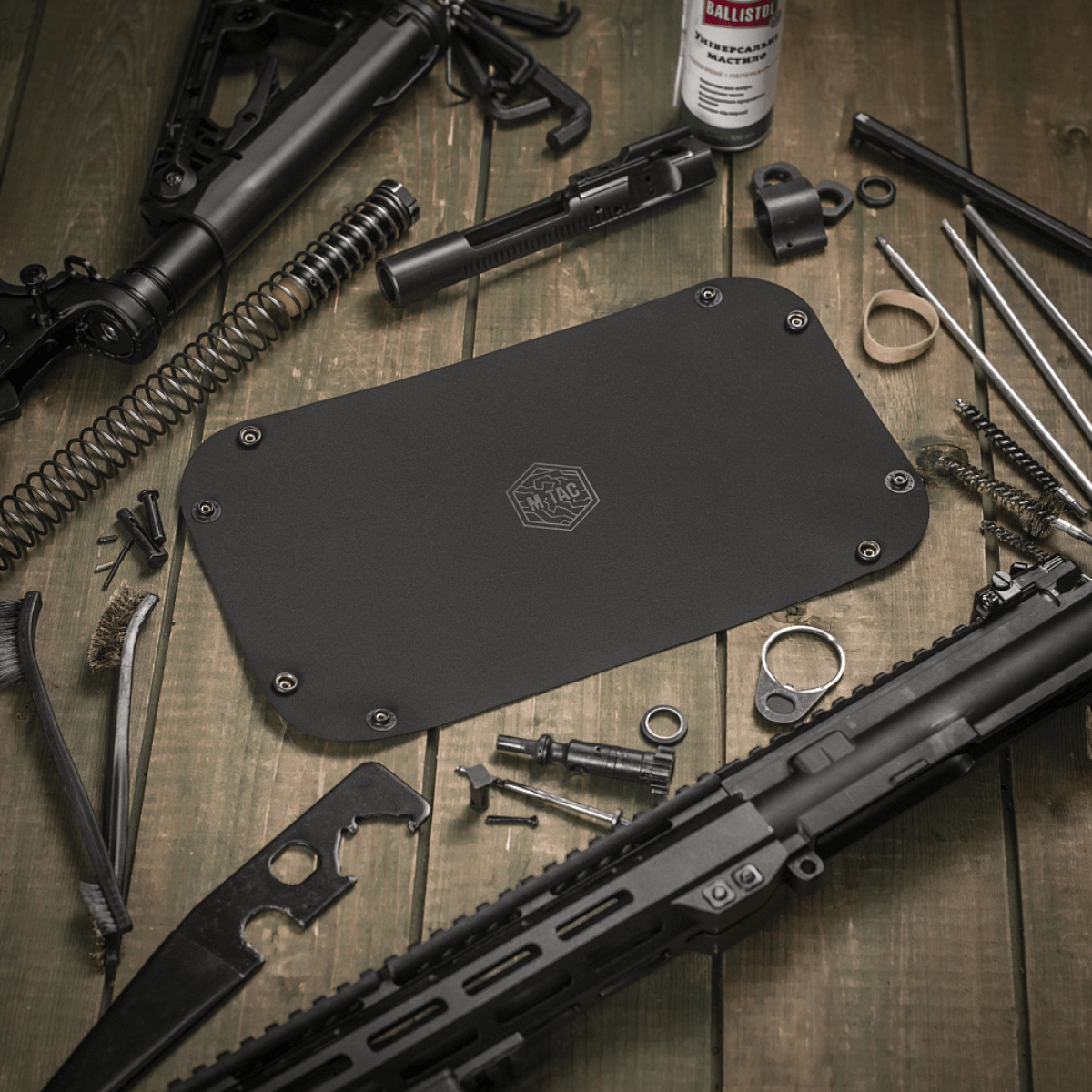 M‑Tac Field Vedligeholdelsesbakke 18x30 cm brugt til våbenvedligeholdelse, omgivet af værktøj og dele, polymerkomposit materiale.