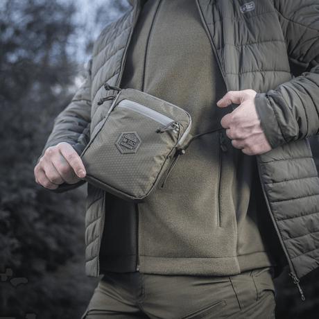 Mand bærer M‑Tac Pocket Bag Elite HEX udendørs. Kompakt og holdbar taske til EDC-udstyr med YKK lynlås. Ideel til daglig brug.
