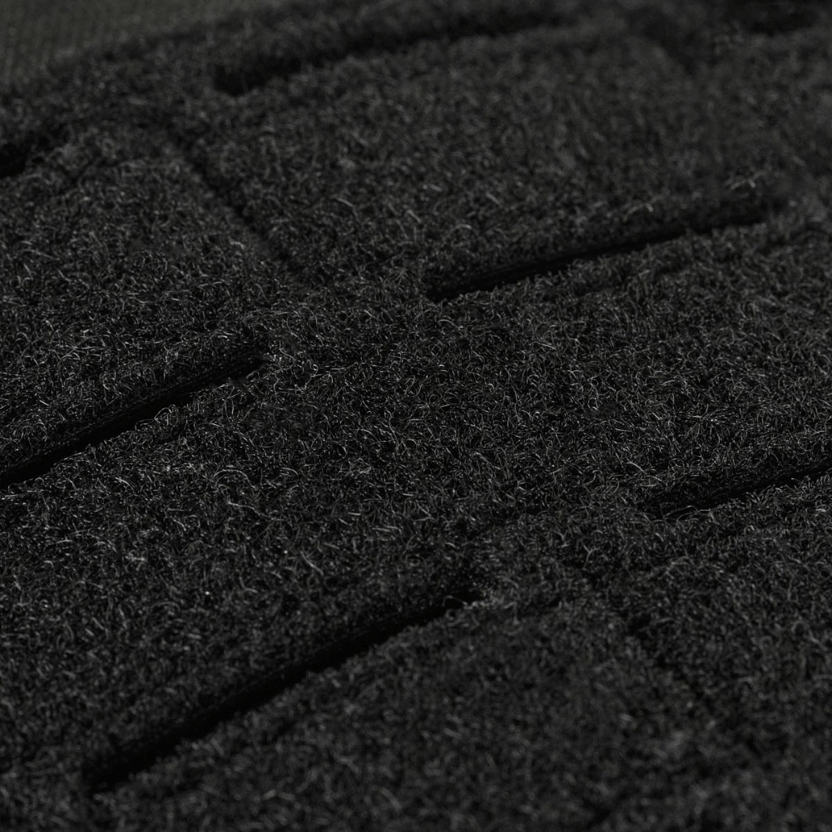 Nærbillede af sort stof med grov tekstur, der viser detaljerne i materialets overflade. Perfekt til taktile applikationer.