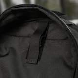 Sort taske med lynlåsdel og sort håndtag, set indefra