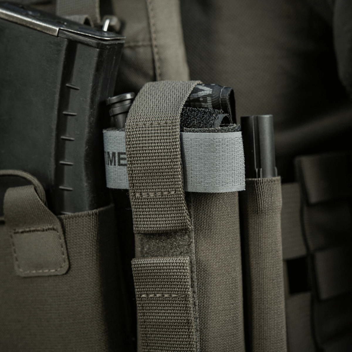 M‑Tac Tourniquet Pouch Elastic Gen.5 monteret på taktisk udstyr med elastisk bånd og velcro for sikker opbevaring af CAT tourniquet