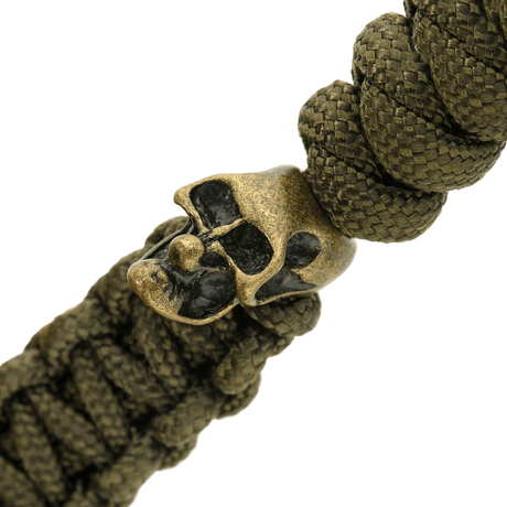 Detalje af olivengrøn M-Tac Loopy Snake Skull Lanyard, vist med flettet paracord og dekorativt kranie i metal, til kniv og udstyr.
