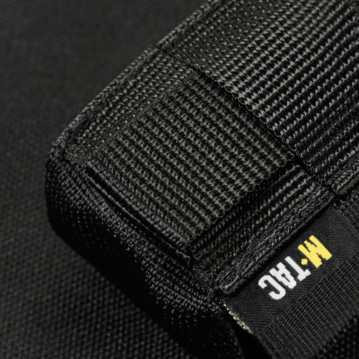 M-Tac Gasdåseholder Vertikal i sort med robust MIL-SPEC strop og Woojin-lås, ideel til montering på MOLLE-systemer.