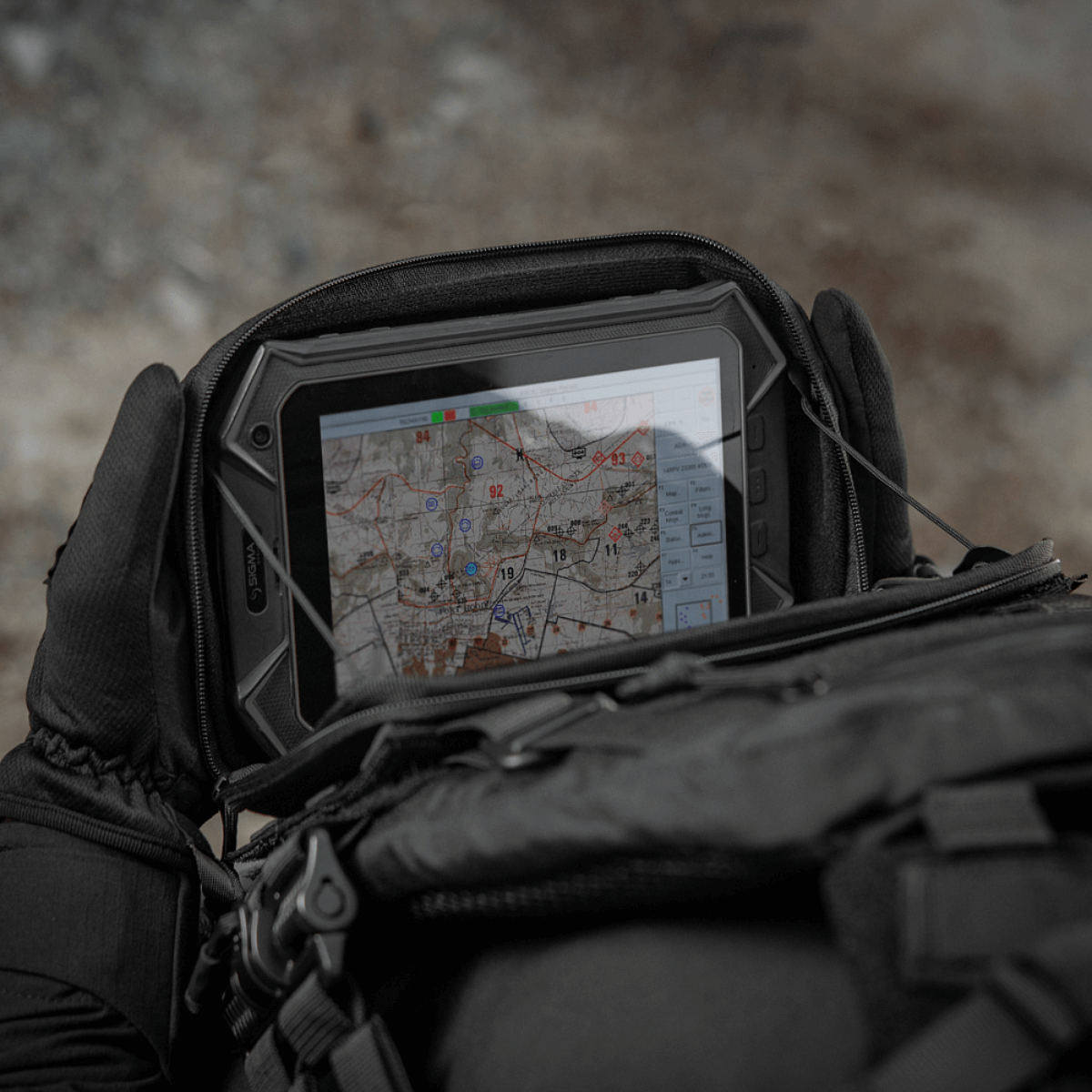 M-Tac Admin Pouch Large Elite med et kort i felten, monteret på en taktisk rygsæk til udendørs brug.