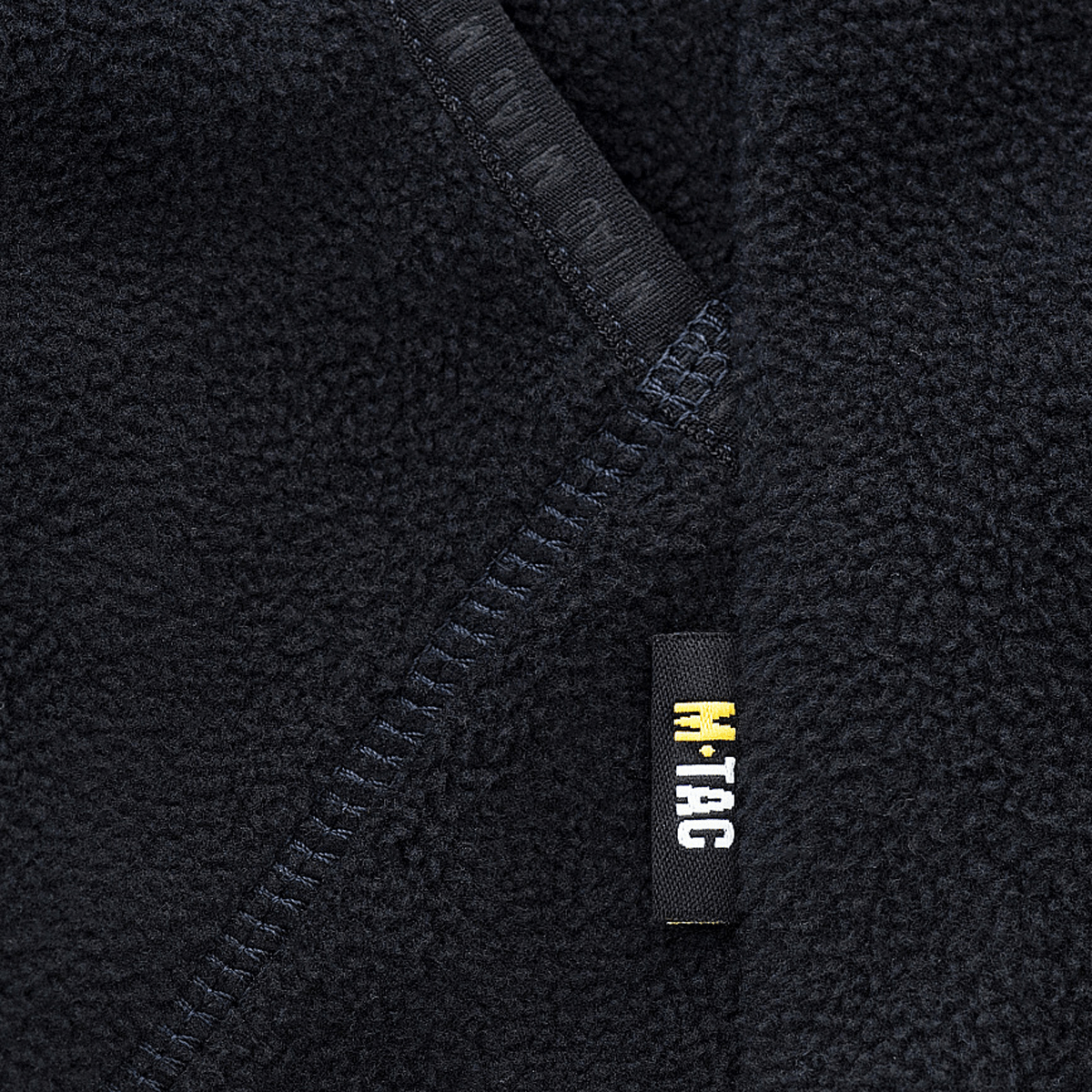 Nærbillede af M-Tac Lite Microfleece Hættetrøje detaljer, elastisk kant og logo for komfort og stil.