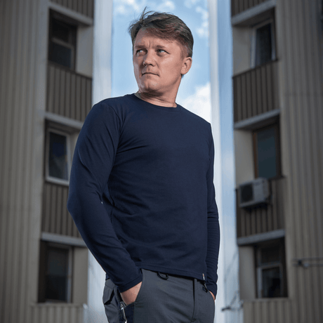 Mand iført M-Tac Long-sleeve T-shirt 93/7 fremhæver muskelkonturer mod en bybaggrund.