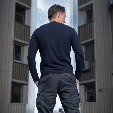 M-Tac Long-sleeve T-shirt 93/7 på en mand i bymiljø, 93% bomuld, 7% elastan, ideel til hverdag, uniform og friluftsliv