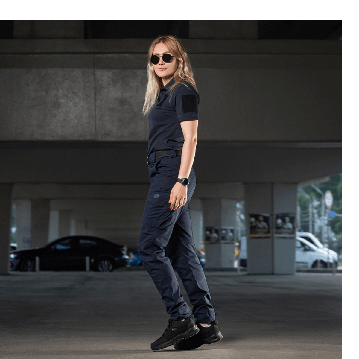 Kvinde iført M-Tac Bukser Aggressor Dame Flex til træning og forretningsrejser, lavet af let materiale med Teflon-impregnering.