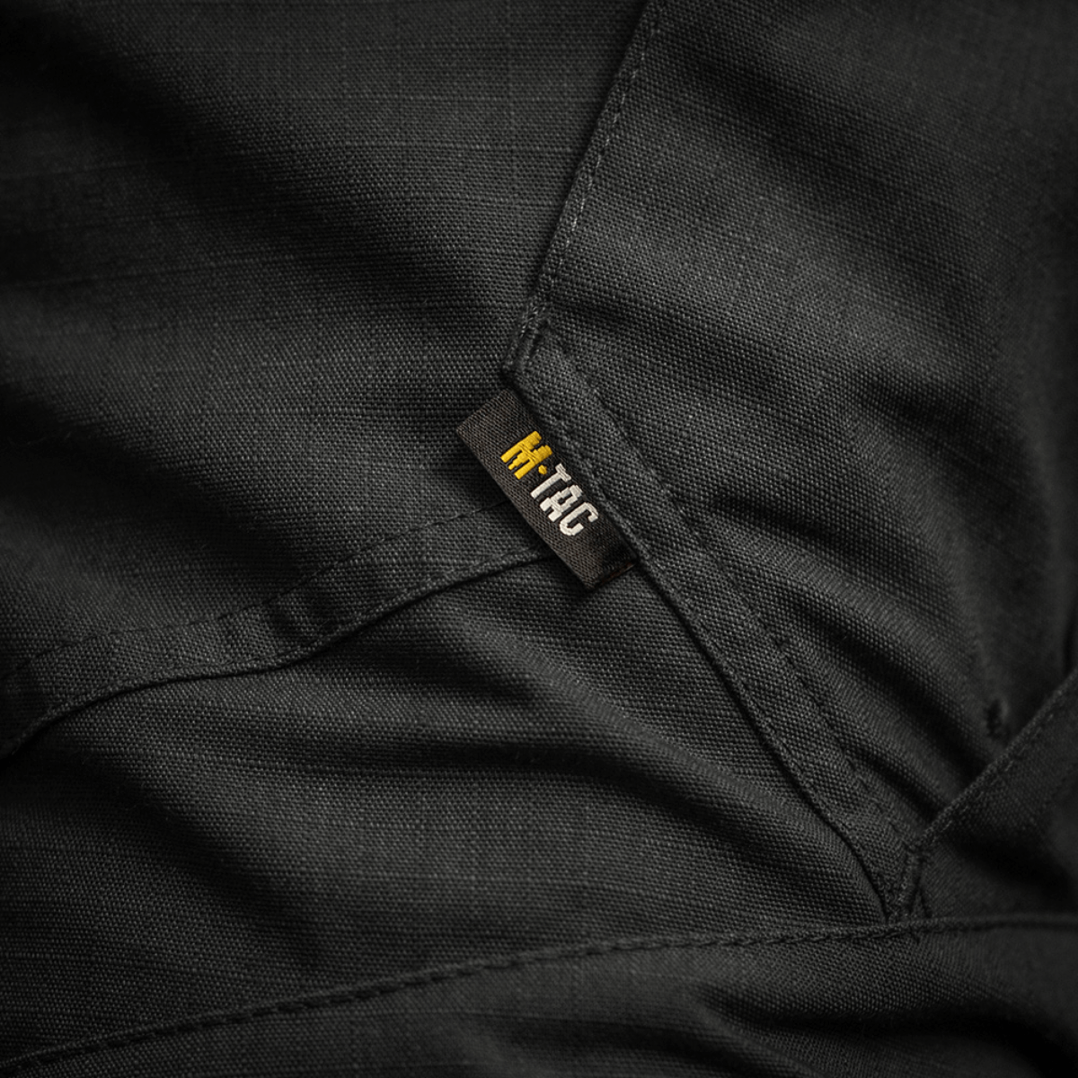 Detaljebillede af M-Tac Bukser STURM NyCo Extreme Gen.II, viser holdbar NYCO Extreme-stof og M-Tac-mærketikette.