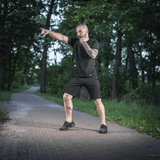 Mand i skoven iført M-Tac Shorts Casual Fit Cotton træner i sommervejr, viser stilrent design og høj komfort.