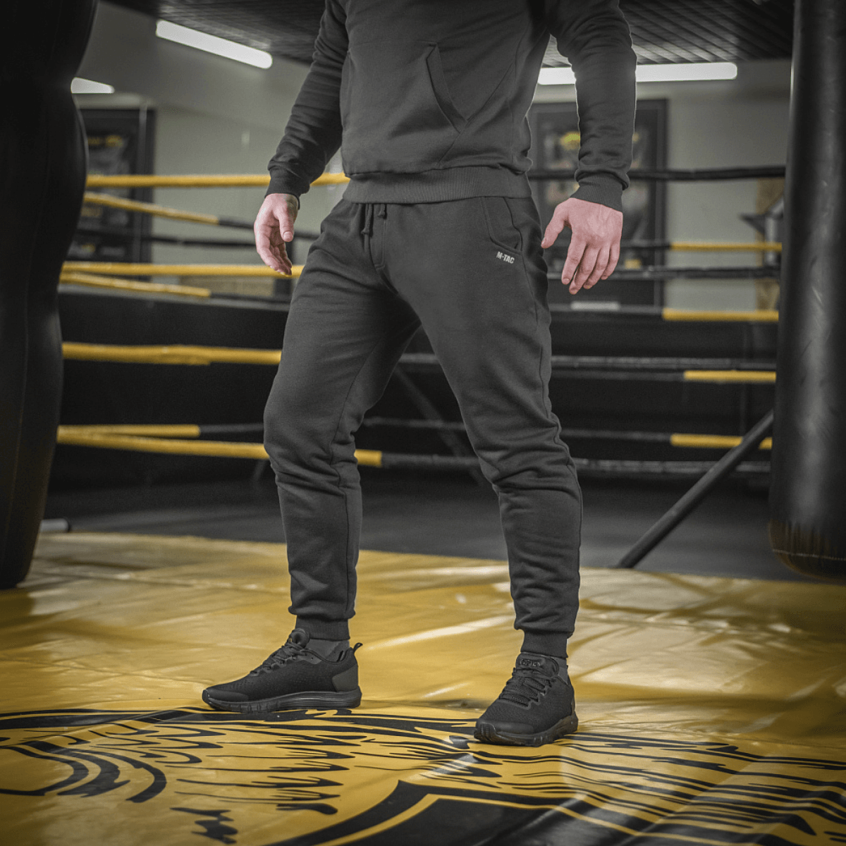 Mand iført M-Tac Bukser Cotton Classic i træningscenter, viser alsidighed og komfort til sport og daglig brug.