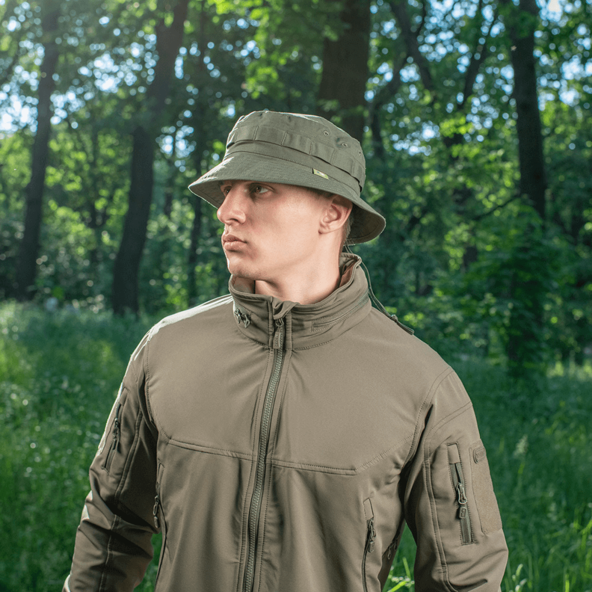 Mand iført M-Tac Panama Rip-Stop army-hat med semi-stiv skygge og ventilationshuller, stående i en skov. Inspireret af Boonie-model.