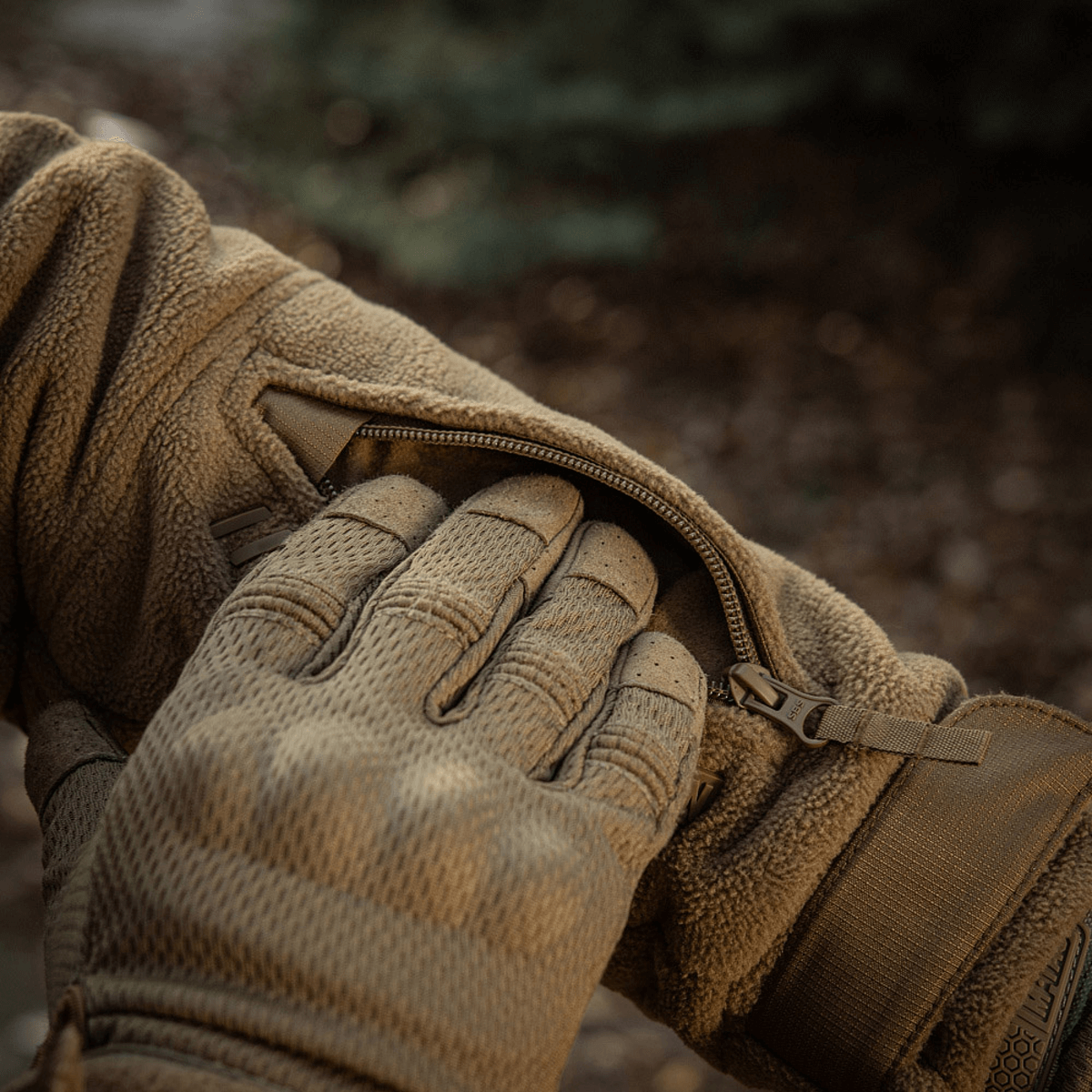Nærbillede af lynlåsen på M-Tac Division Gen.II Windblock Fleecejakke i brug udendørs, viser materialet og design.