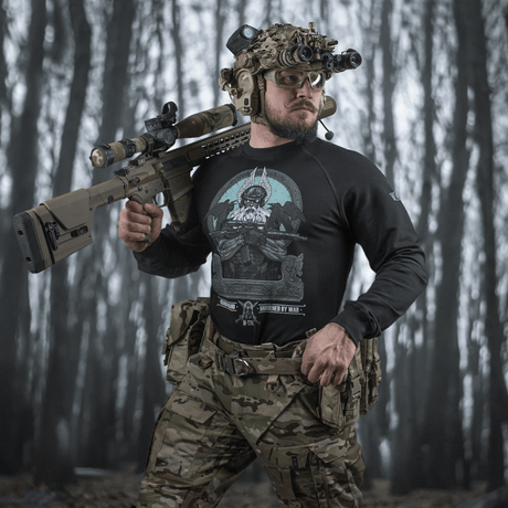 Mand iført M-Tac Raglan Odin Mystery med Odin-motiv i skovmiljø, perfekt til taktisk stil. Lavet af 95% bomuld, 5% elastan.