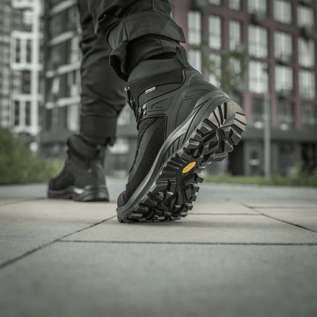 M-Tac Taktiske Demi-Season Støvler Pro Line med Vibram-sål til taktiske opgaver, visning af bund og greb i bymiljø.
