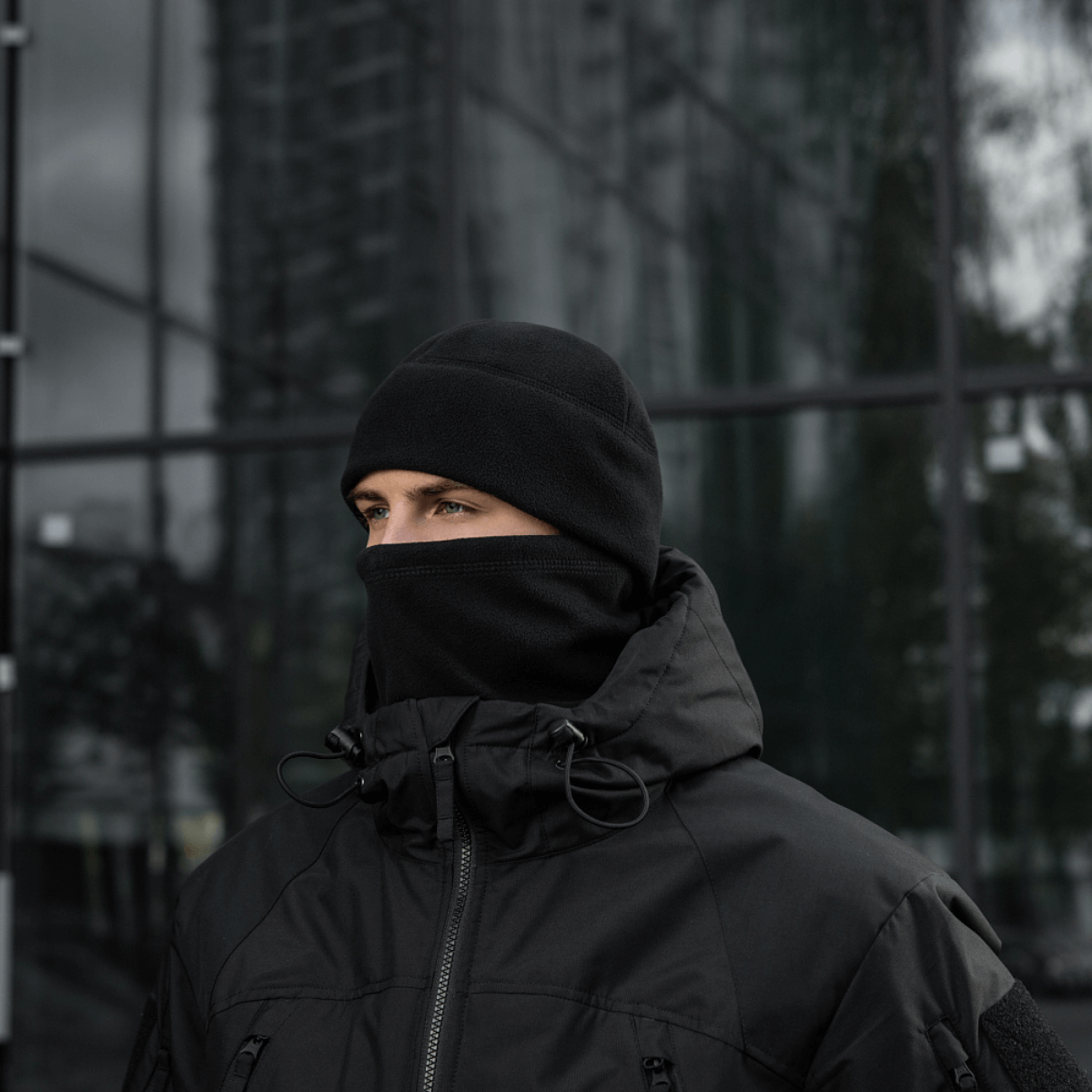 Person iført M-Tac Watch Cap Elite Fleece Beanie Hat Slimtex i koldt vejr; varm og let hue, perfekt til taktisk brug eller friluftsliv.