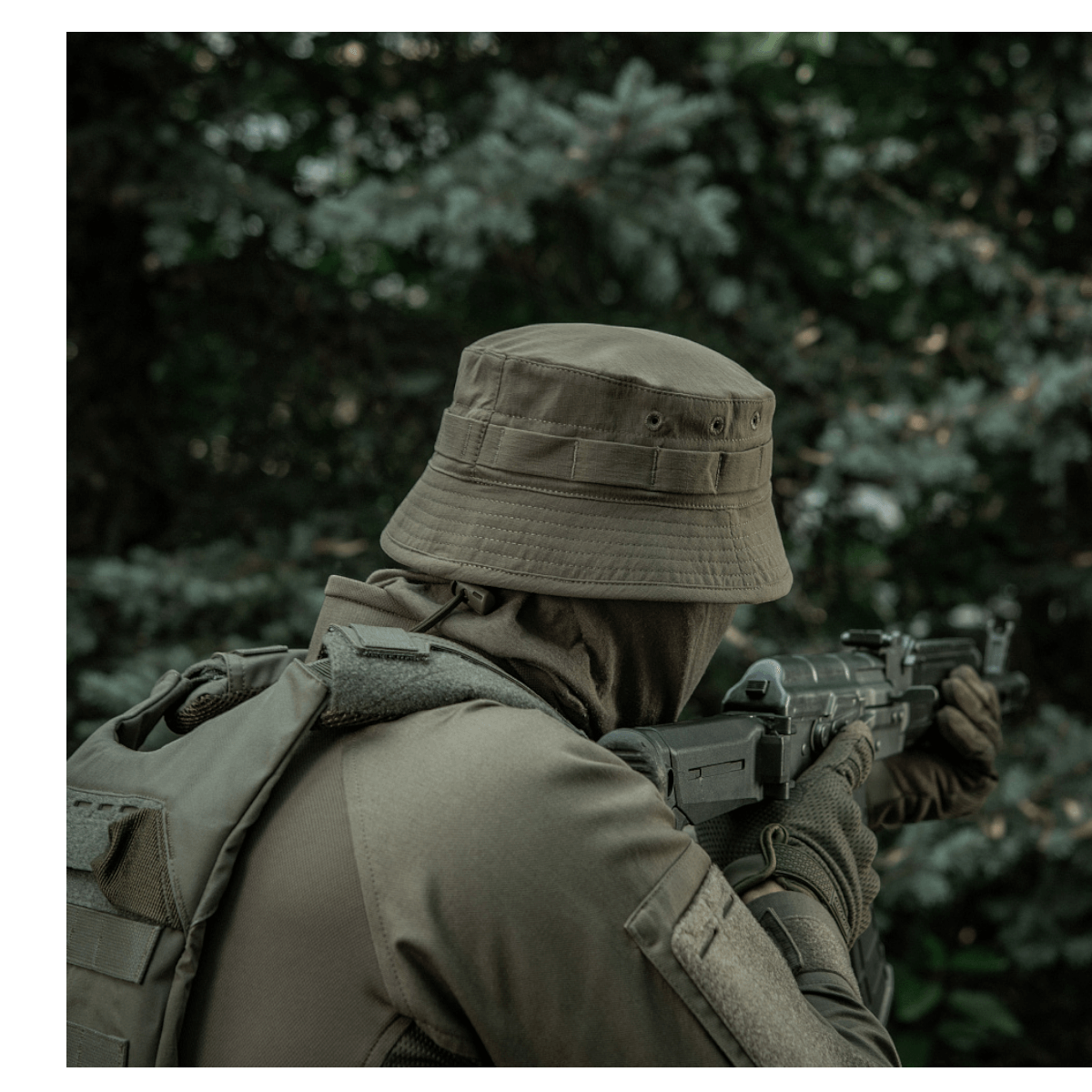 Person iført M-Tac Panamahat Gen. II Summer Flex i en skovmiljø, der demonstrerer solbeskyttelse og komfort